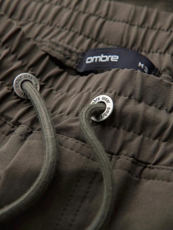 Ombre Clothing Pánske bežecké nohavice s vreckami a potlačou tmavo olivovo zelená Oblečenie Ombre